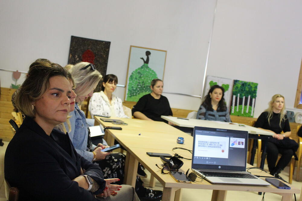 Social workers sitting around a table listening to HBSC surveillance findings during a training session