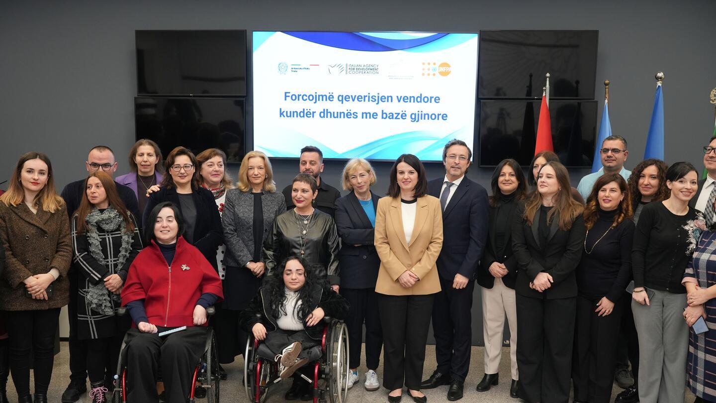 Group photo of participants at the project launch ceremony, standing in front of a screen displaying the project title and partner logos