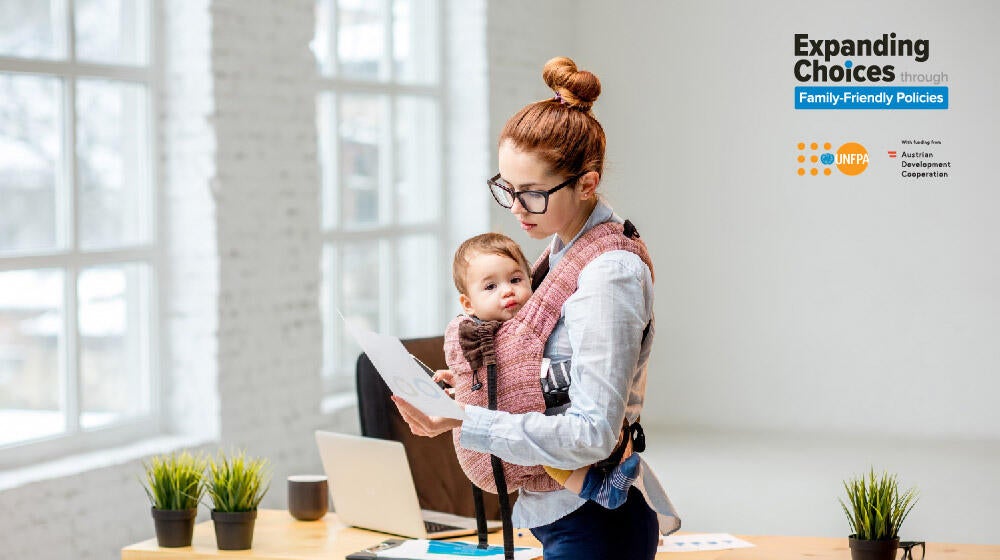 Illustrative cover image. A mother taking care of her newborn and working in the mean time at home. 